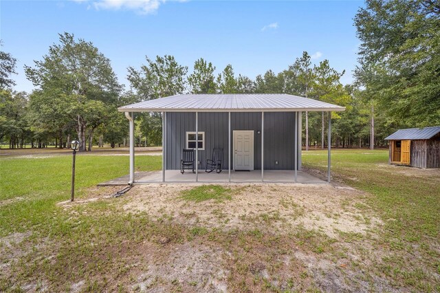 rear view of house with an outdoor structure and a yard