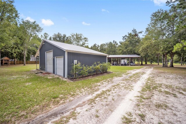 view of side of property featuring a garage, an outdoor structure, and a lawn