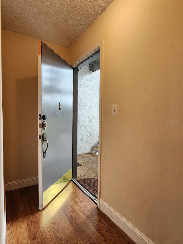 entryway with hardwood / wood-style flooring and a textured ceiling