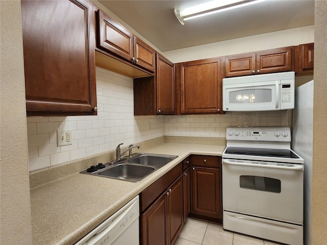 kitchen with backsplash, sink, light tile patterned floors, and white appliances