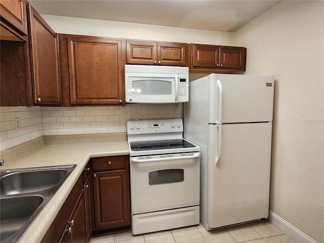 kitchen with white appliances, light tile patterned floors, backsplash, and sink