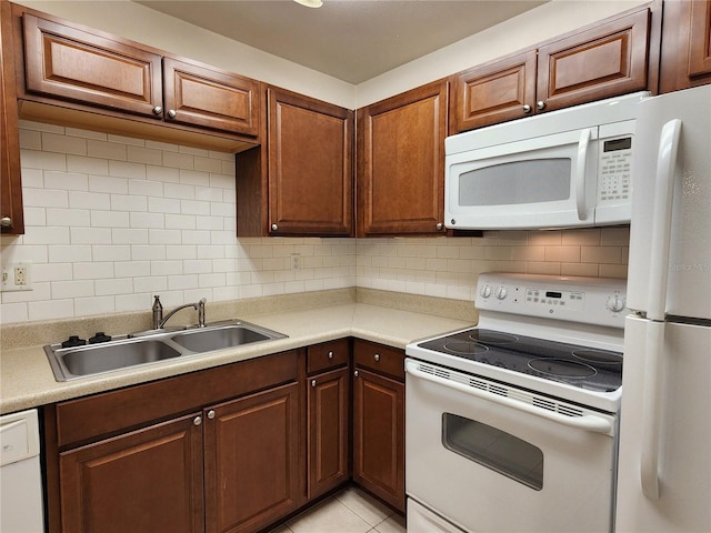 kitchen with white appliances, light tile patterned floors, tasteful backsplash, and sink