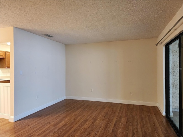 unfurnished room featuring a textured ceiling and hardwood / wood-style flooring