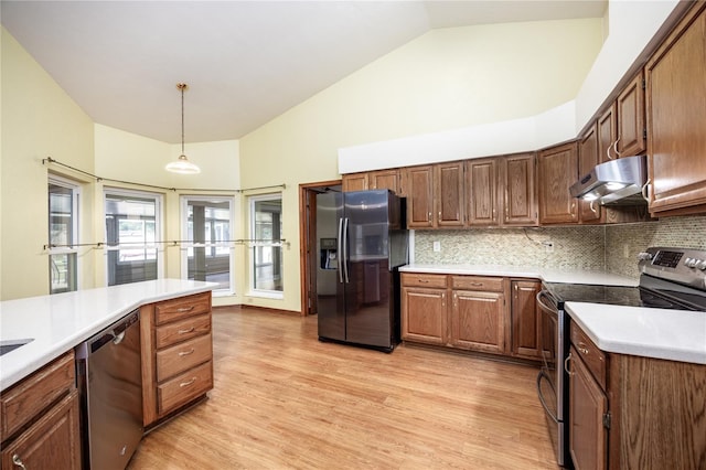 kitchen featuring backsplash, appliances with stainless steel finishes, hanging light fixtures, high vaulted ceiling, and light wood-type flooring