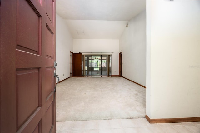 carpeted spare room with lofted ceiling