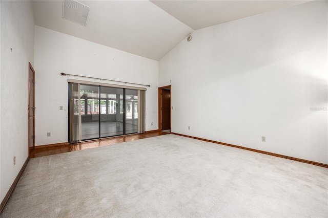 spare room with high vaulted ceiling and wood-type flooring