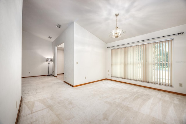 empty room with lofted ceiling, light carpet, and a chandelier