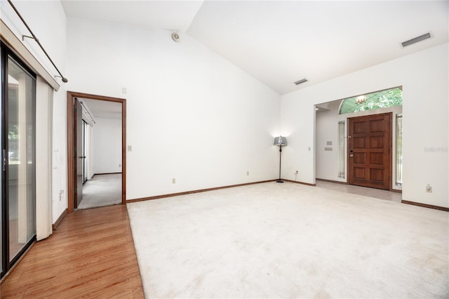 carpeted empty room featuring high vaulted ceiling