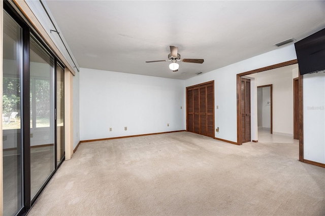 spare room featuring light colored carpet and ceiling fan