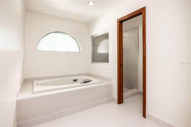 bathroom featuring tiled bath and tile patterned floors