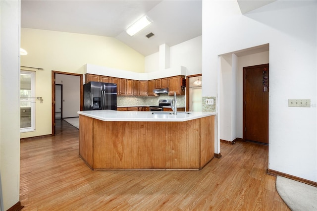 kitchen with light hardwood / wood-style flooring, stainless steel electric range, decorative backsplash, and black refrigerator with ice dispenser