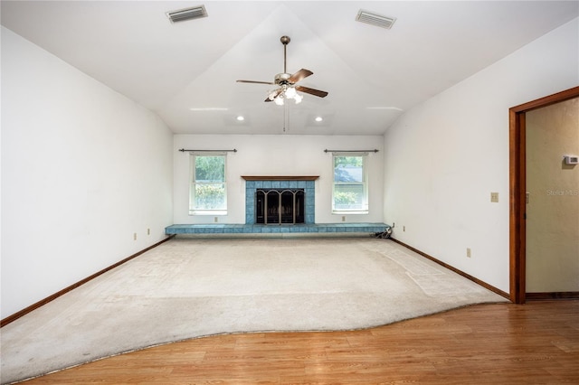 unfurnished living room with a fireplace, vaulted ceiling, wood-type flooring, and ceiling fan