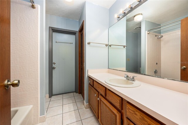 bathroom with vanity, tiled shower / bath, and tile patterned floors