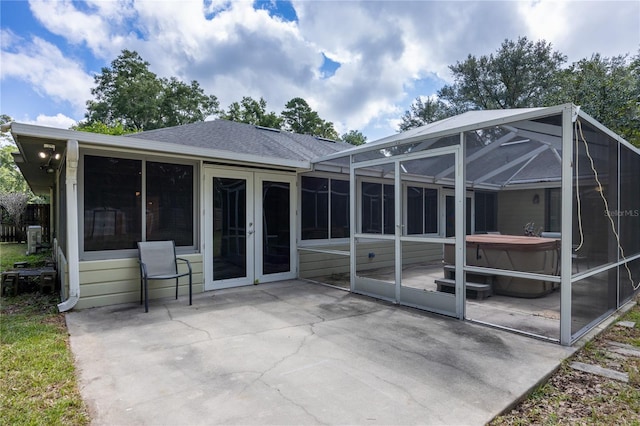 rear view of house featuring a patio and glass enclosure