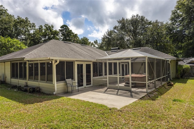 back of house featuring a sunroom, a lawn, and a patio