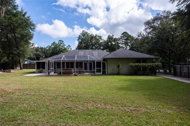 rear view of house featuring a lawn and a lanai