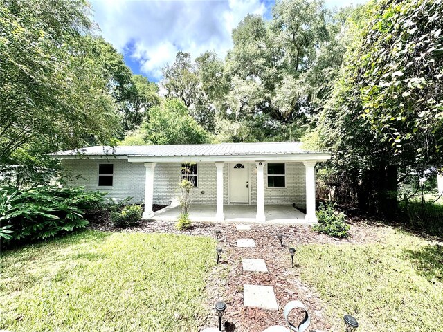 rear view of house with a yard and a patio