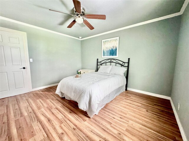 bedroom with ceiling fan, ornamental molding, and light hardwood / wood-style floors