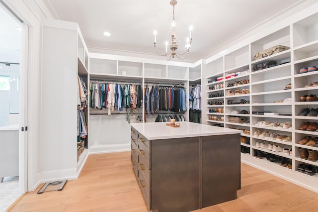 spacious closet with an inviting chandelier and light wood-type flooring