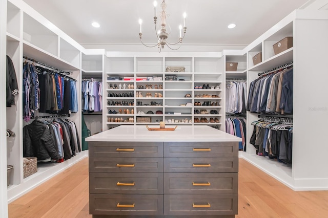 walk in closet featuring light hardwood / wood-style floors and an inviting chandelier