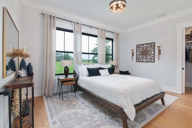 bedroom featuring light hardwood / wood-style flooring and ornamental molding