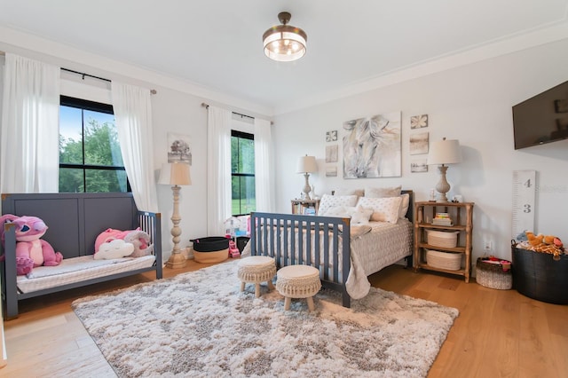 bedroom with hardwood / wood-style flooring and crown molding