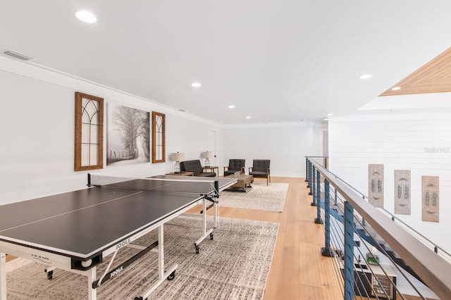 rec room featuring light wood-type flooring and ornamental molding