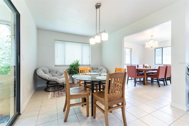 tiled dining room featuring a chandelier