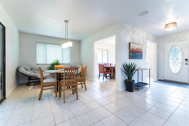 tiled dining area featuring a chandelier