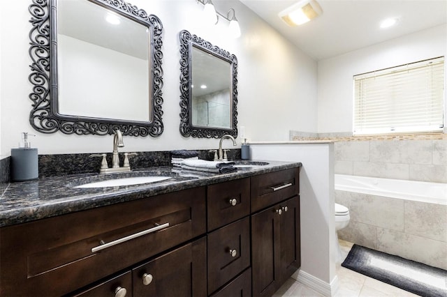 bathroom featuring tile patterned floors, vanity, a relaxing tiled tub, and toilet