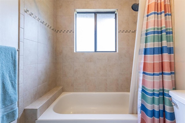 bathroom with shower / bath combo, toilet, and plenty of natural light