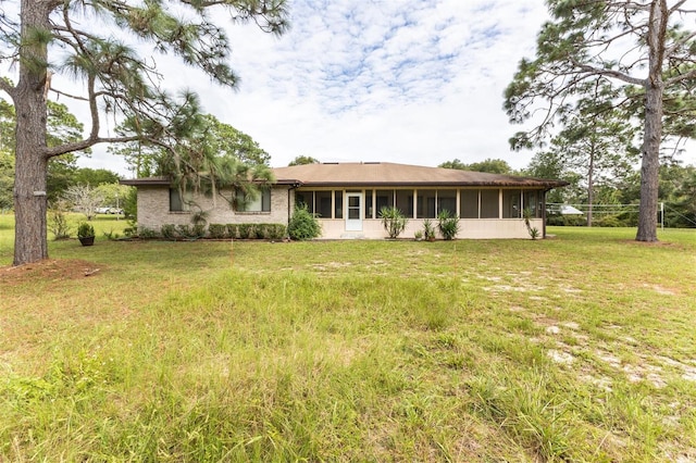 view of front of home with a front lawn and a sunroom