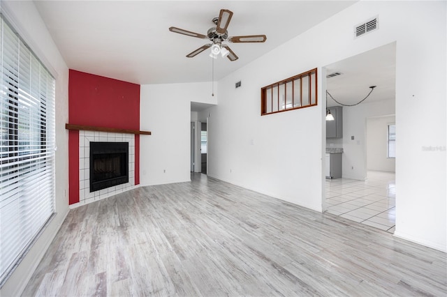 unfurnished living room with light hardwood / wood-style flooring, ceiling fan, and a tile fireplace