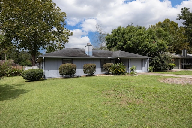 view of front of home with a garage and a front lawn