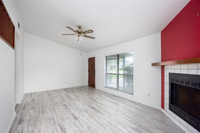 unfurnished living room featuring a fireplace, light hardwood / wood-style flooring, and ceiling fan