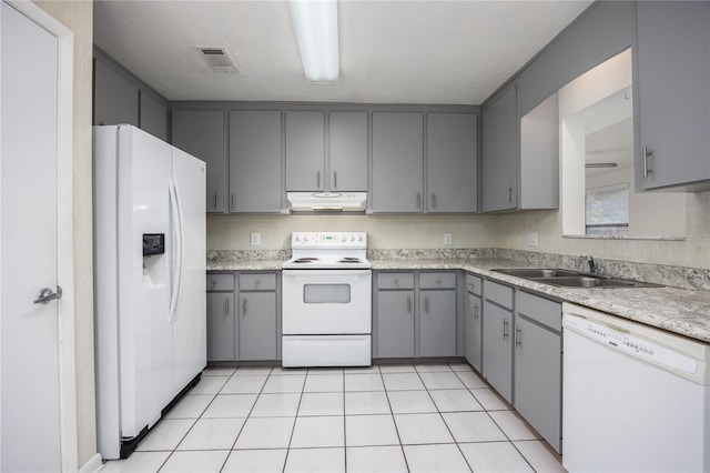 kitchen with gray cabinetry, sink, light tile patterned floors, and white appliances