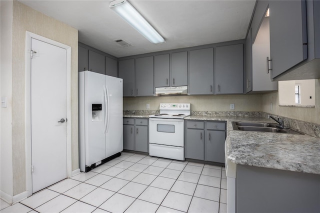 kitchen featuring white appliances, light tile patterned floors, gray cabinetry, and sink