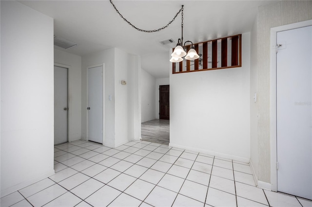 unfurnished dining area featuring light tile patterned floors and a notable chandelier