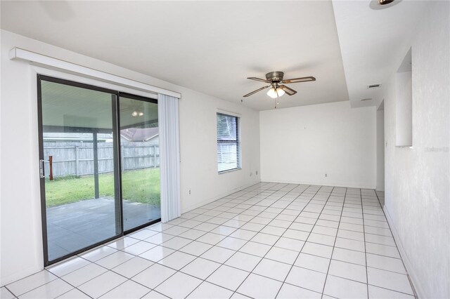 tiled spare room with a healthy amount of sunlight and ceiling fan