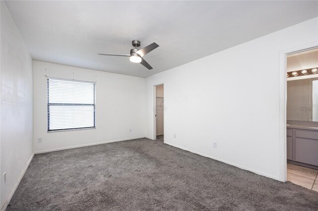 unfurnished bedroom with ensuite bath, ceiling fan, and carpet floors