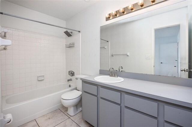 full bathroom featuring tile patterned flooring, vanity, toilet, and tiled shower / bath