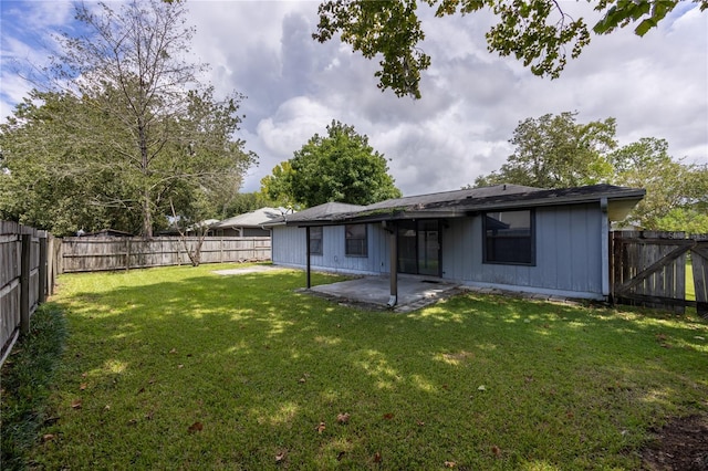 rear view of house with a yard and a patio