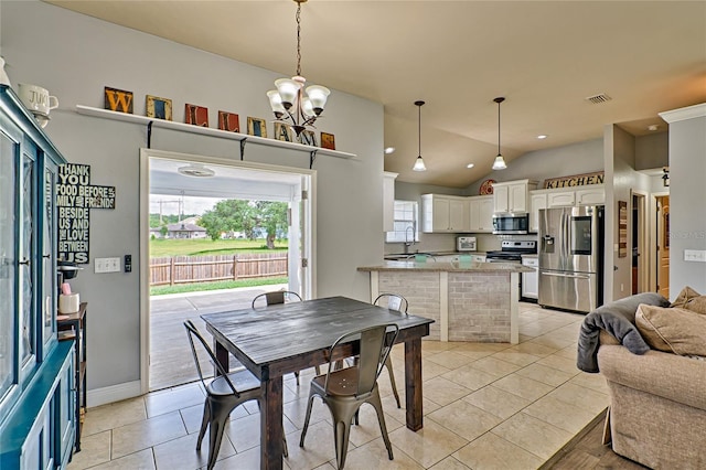 dining space featuring an inviting chandelier, lofted ceiling, light tile patterned floors, and sink