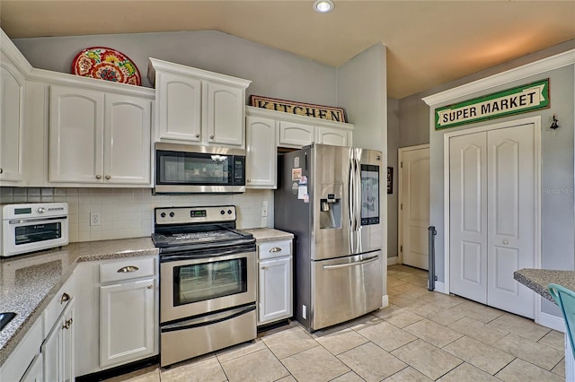 kitchen featuring lofted ceiling, stainless steel appliances, and white cabinetry