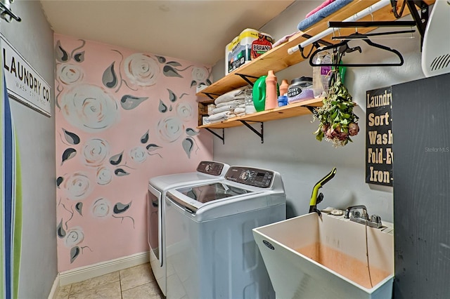 washroom featuring light tile patterned floors, washing machine and dryer, and sink