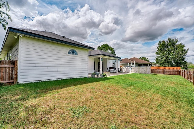 back of house featuring a patio, a fenced backyard, and a yard