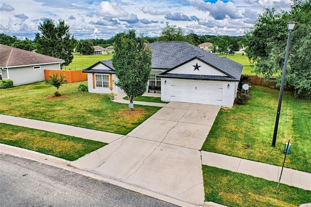 ranch-style home featuring driveway, a garage, fence, and a front yard