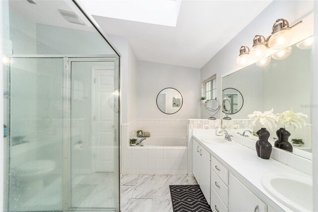 bathroom with plus walk in shower, a skylight, and vanity