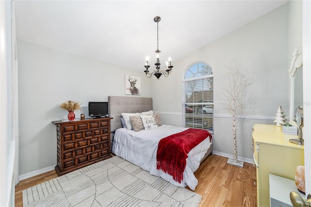 bedroom with a chandelier and light hardwood / wood-style flooring