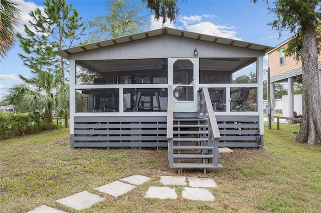 rear view of house with a sunroom and a lawn